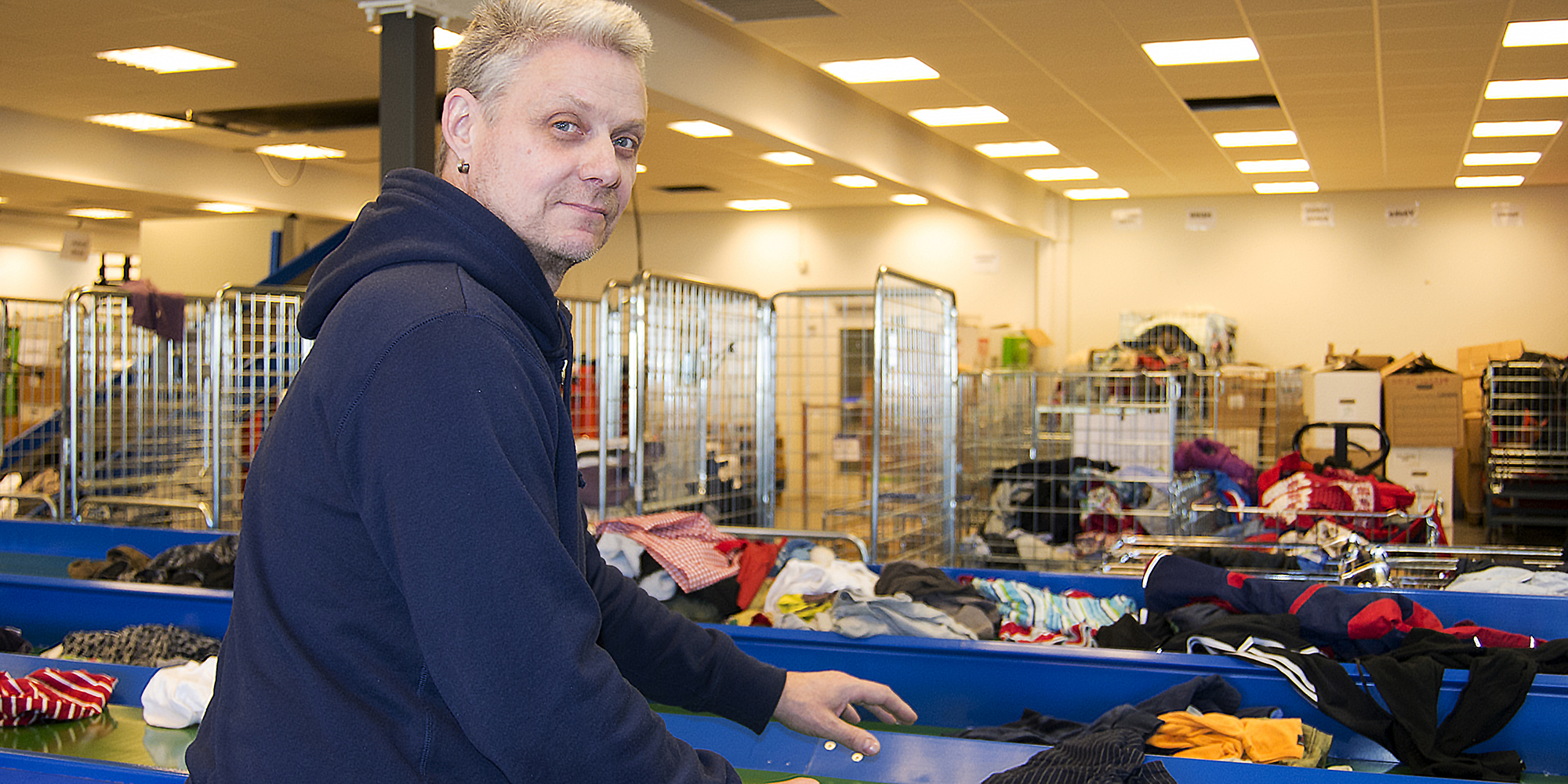 Thomas framför lådor med textilier på Stockholms Stadsmissions centrallager