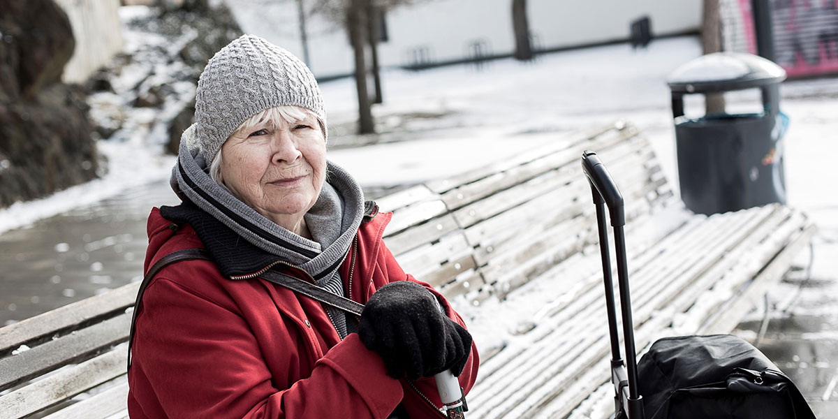 En kvinna sitter på en parkbänk