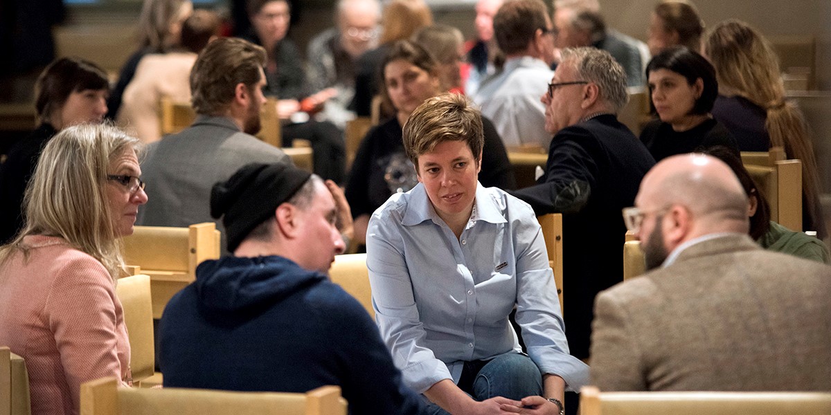 Människor som sitter i ring och pratar med varandra