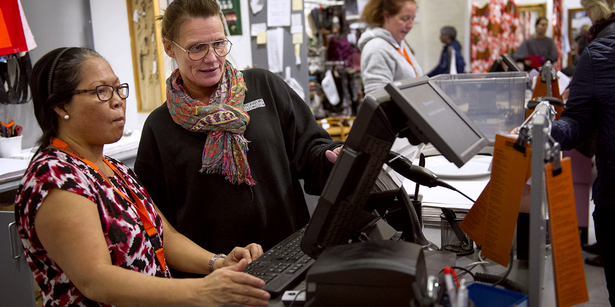 En person får instruktion av kassan Second Hand En person får instruktion av kassan Second Hand