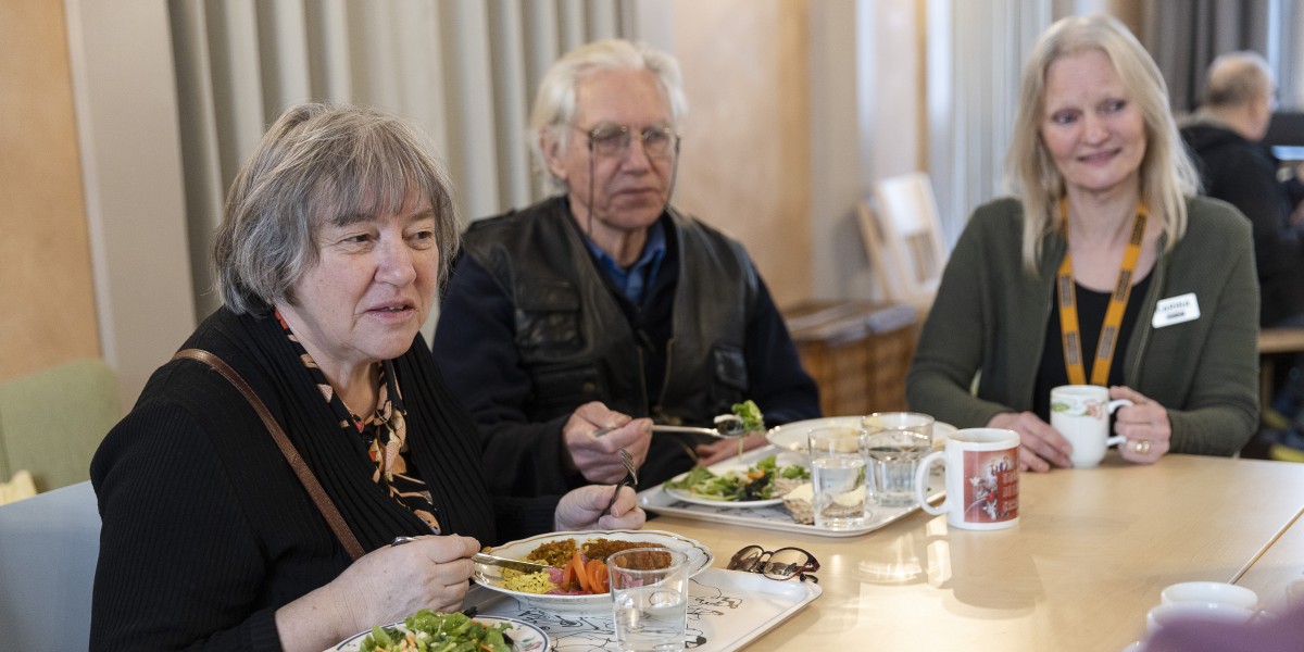 Guy och Agneta och mötesplatsvärden Carina sitter vid bordet och samtalar på Mötesplats Mariatorget.