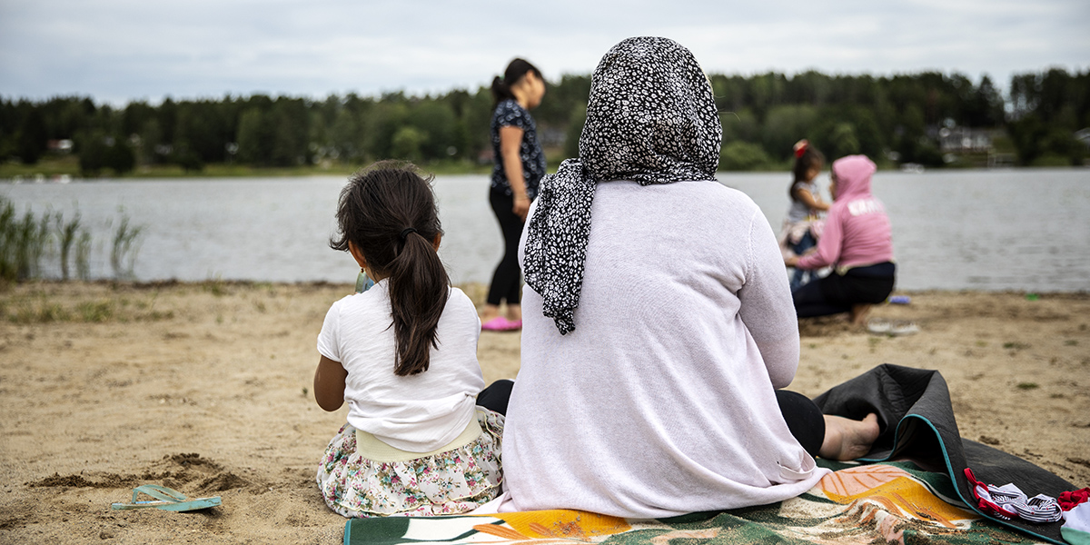 Mamma och barn sitter och värmer sig på badlakan efter bad. Foto: Anna Z Ek