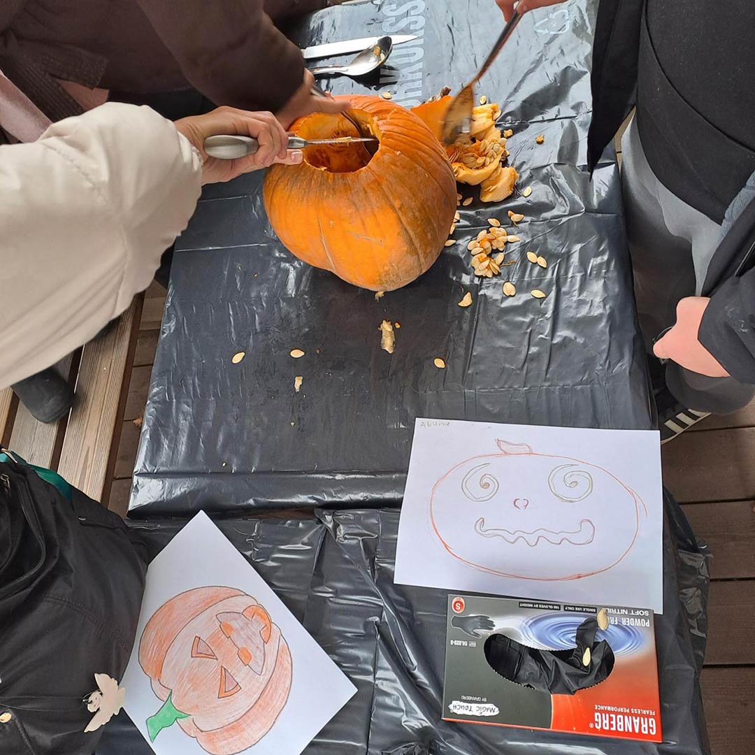 Barn på höstlovskollo gröper ur pumpor.