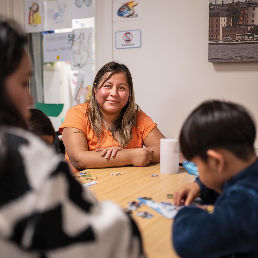 Deltagare sitter vid ett bord på en av Stockholms Stadsmissions mötesplatser.