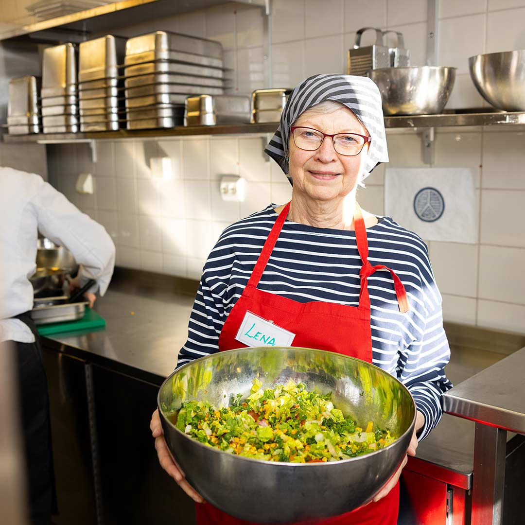 Bild på volontären Lena, tillsammans med en salladskål, på Stockholms Stadsmissions folkhögskola.