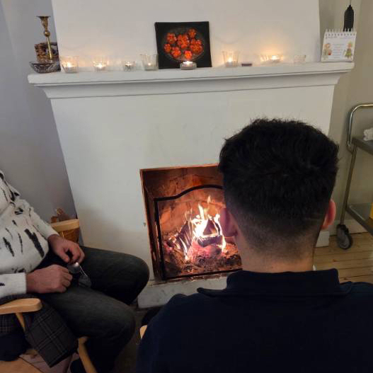 Deltagare framför brasan på Stenfasta.