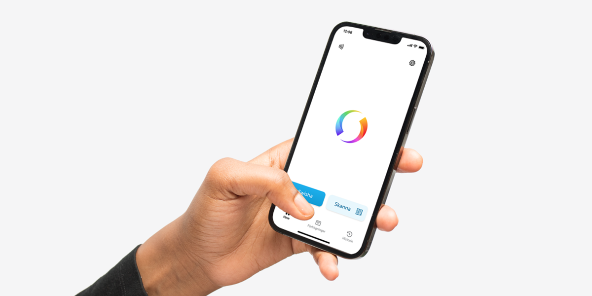 Anonym person som håller i en mobiltelefon och använder appen Swish.