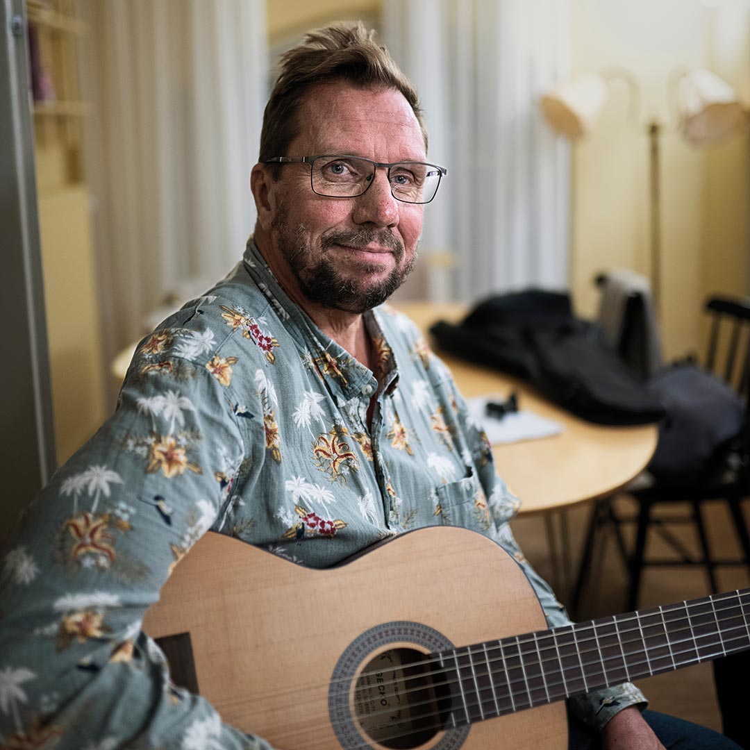 Bild på Thomas med en gitarr på Stockholms Stadsmissions mötesplats Mariatorget.