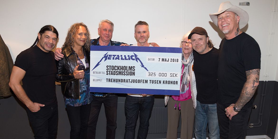 Bandmedlemmarna från Metallica ger en check till deltagare från Äldrecenter
