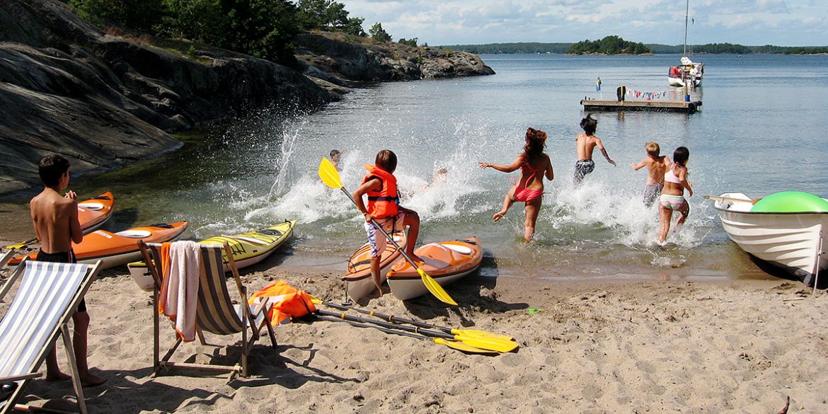 Barn som leker på stranden och badar