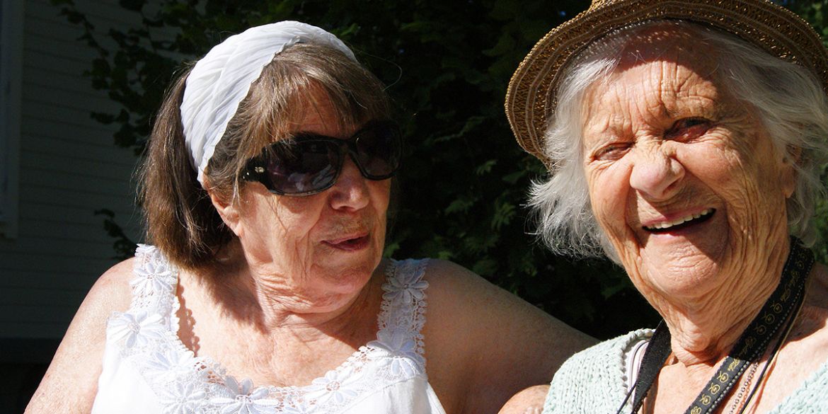 Äldre damer som har trevligt i solen