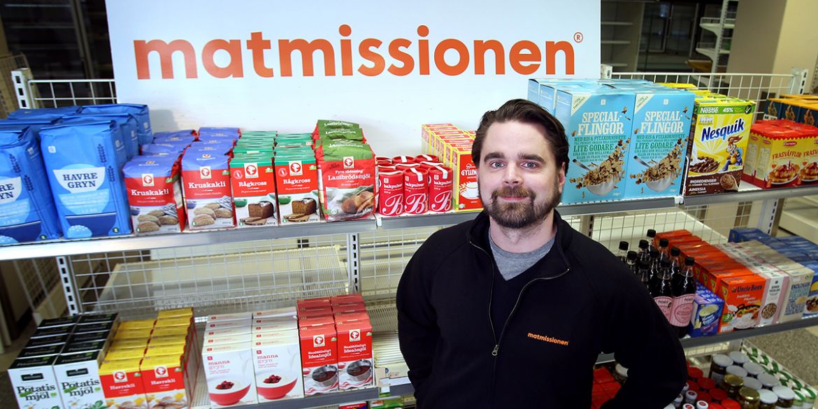 Foto: Stefan Nilsson Johan Rindewall från Stockholms Stadsmission står framför hylla med mat.