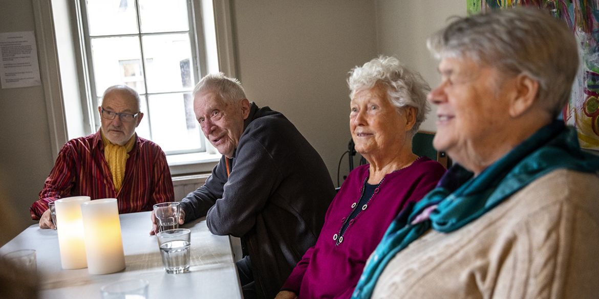 Äldre samtalar runt ett bord - livsberättargrupp Stockholms Stadsmission