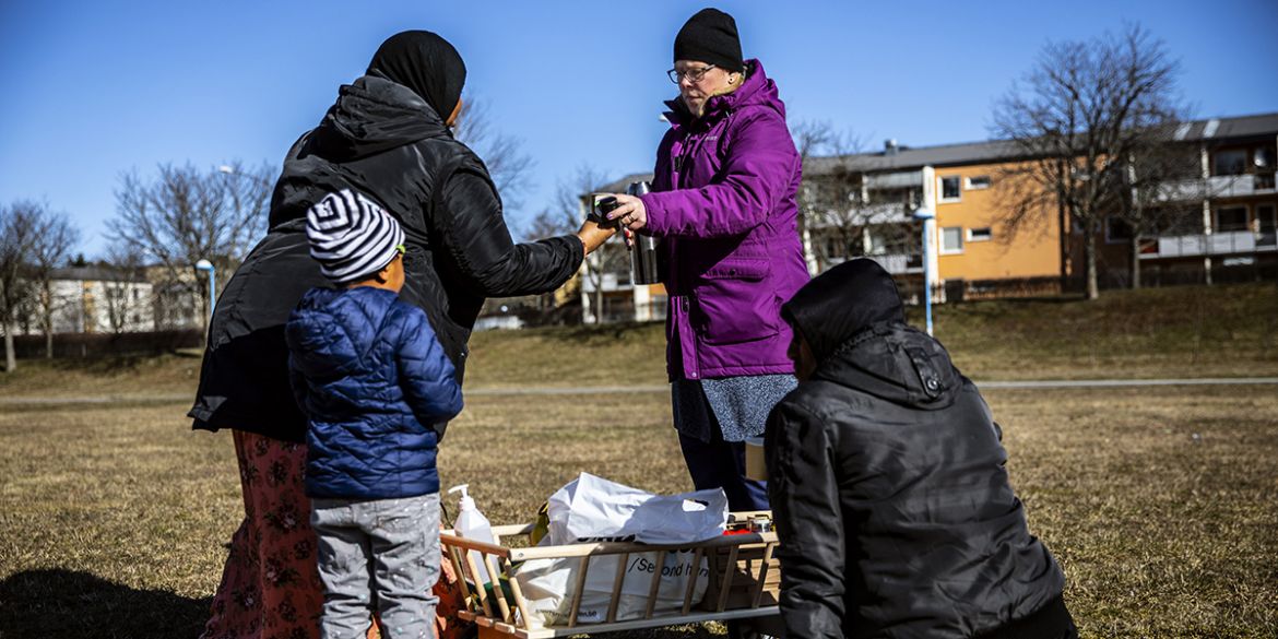 Pernilla, barnombudsman, delar ut fika på Järvafältet till familjer.