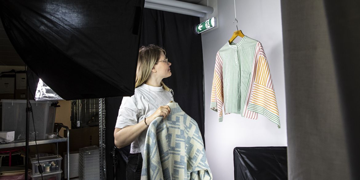 Personal förbereder fotografering i en liten fotostudio med fotoljus.
