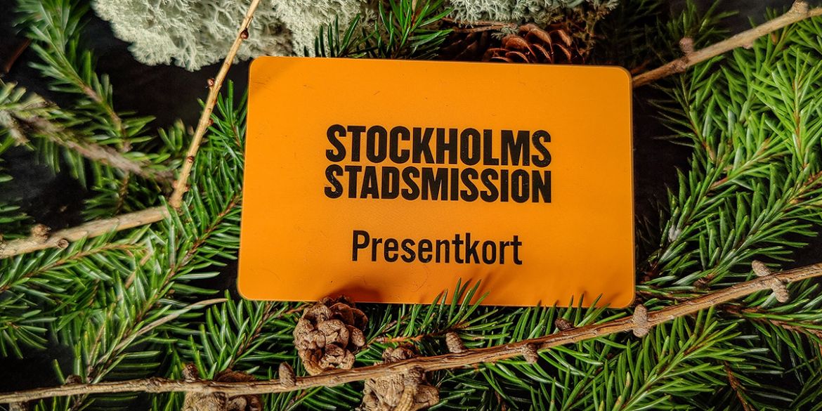 Presentkort från Stockholms Stadsmission ligger på granris.