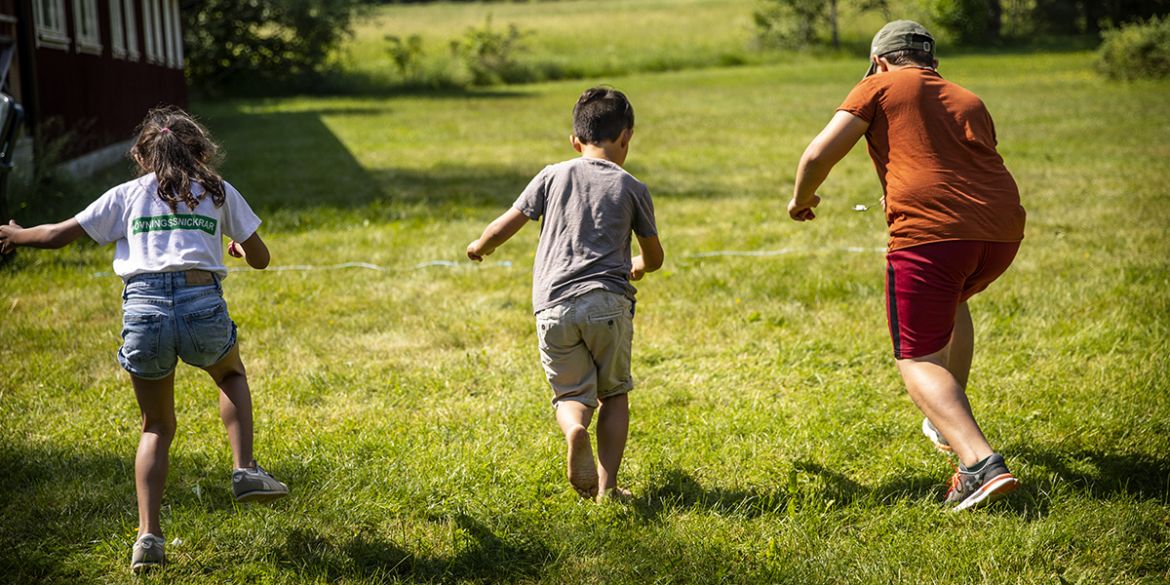 Barn som springer på en gräsmatta.
