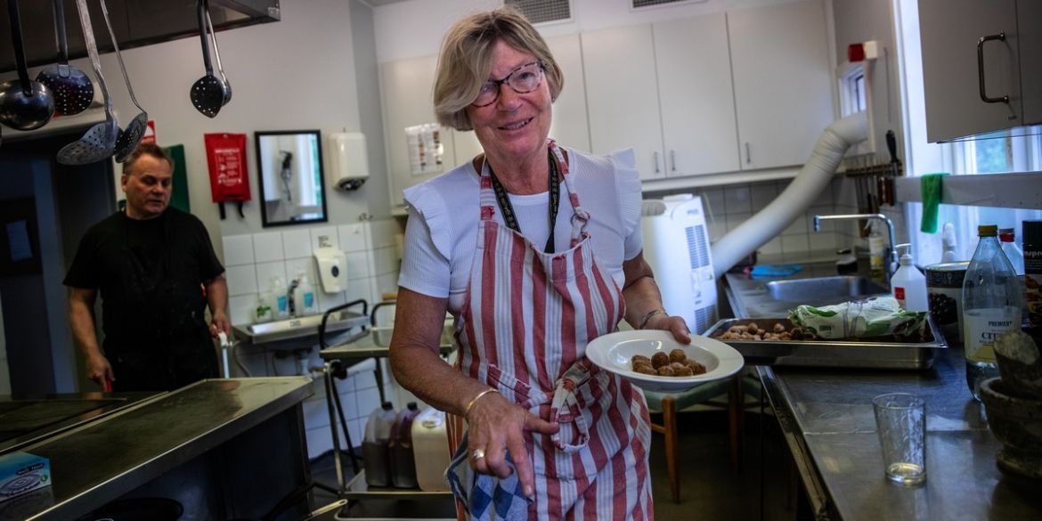 Volontären Ingalena. Foto: Anna Z Ek Kvinna står i ett kök med en tallrik med vegobullar på. Foto: Anna Z Ek