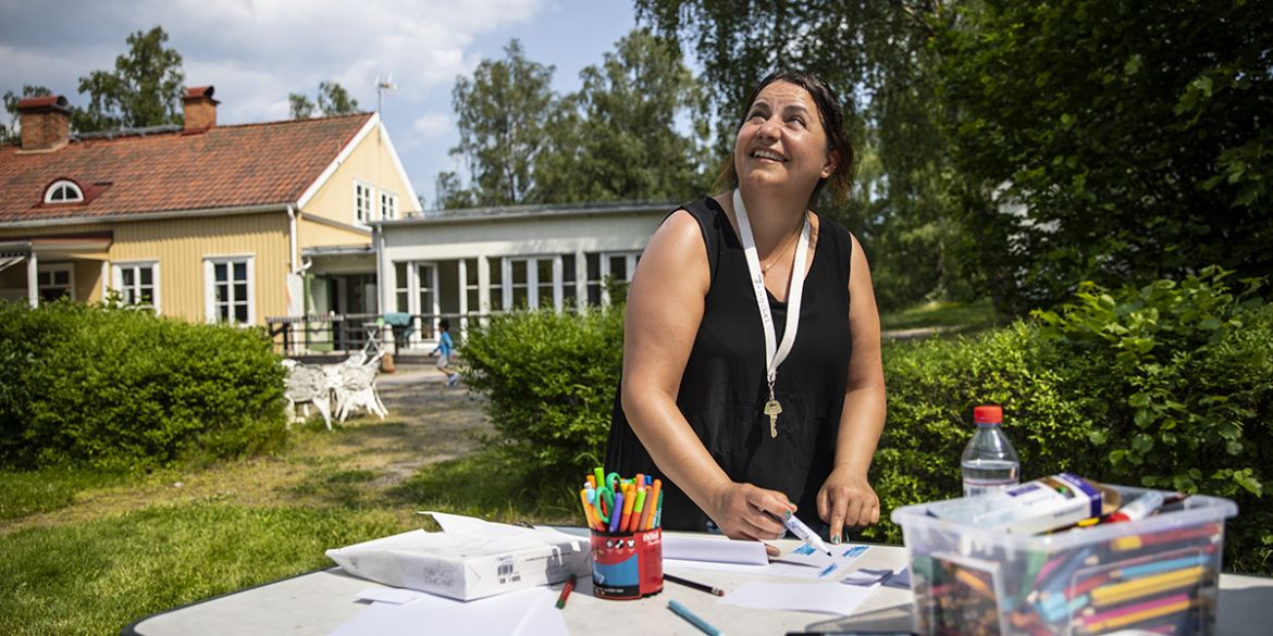 Vid ett bord mitt i solen står volontären Nada Freigi och göra svenska flaggor inför dagens EM-match. Foto: Anna Z Ek
