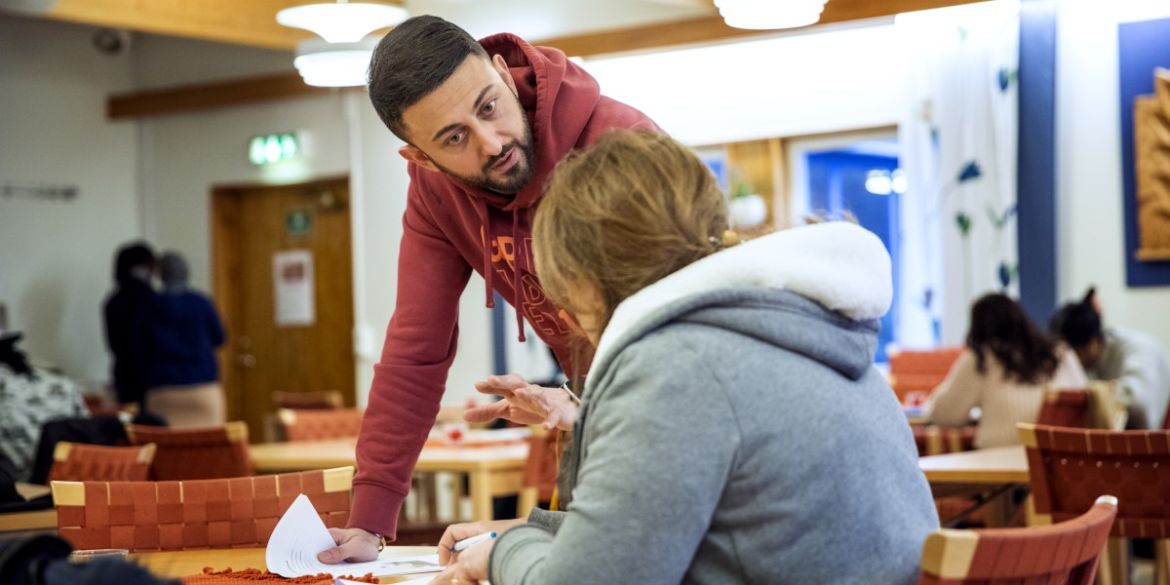 En lärare och elev under en kurs i svenska. En lärare och elev under en kurs i svenska.