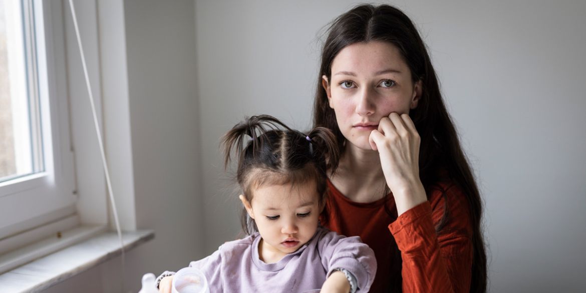 Mamma och dotter sitter i vardagsrum.