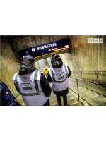 Två personer i reflexväst går ner i tunnelbanan