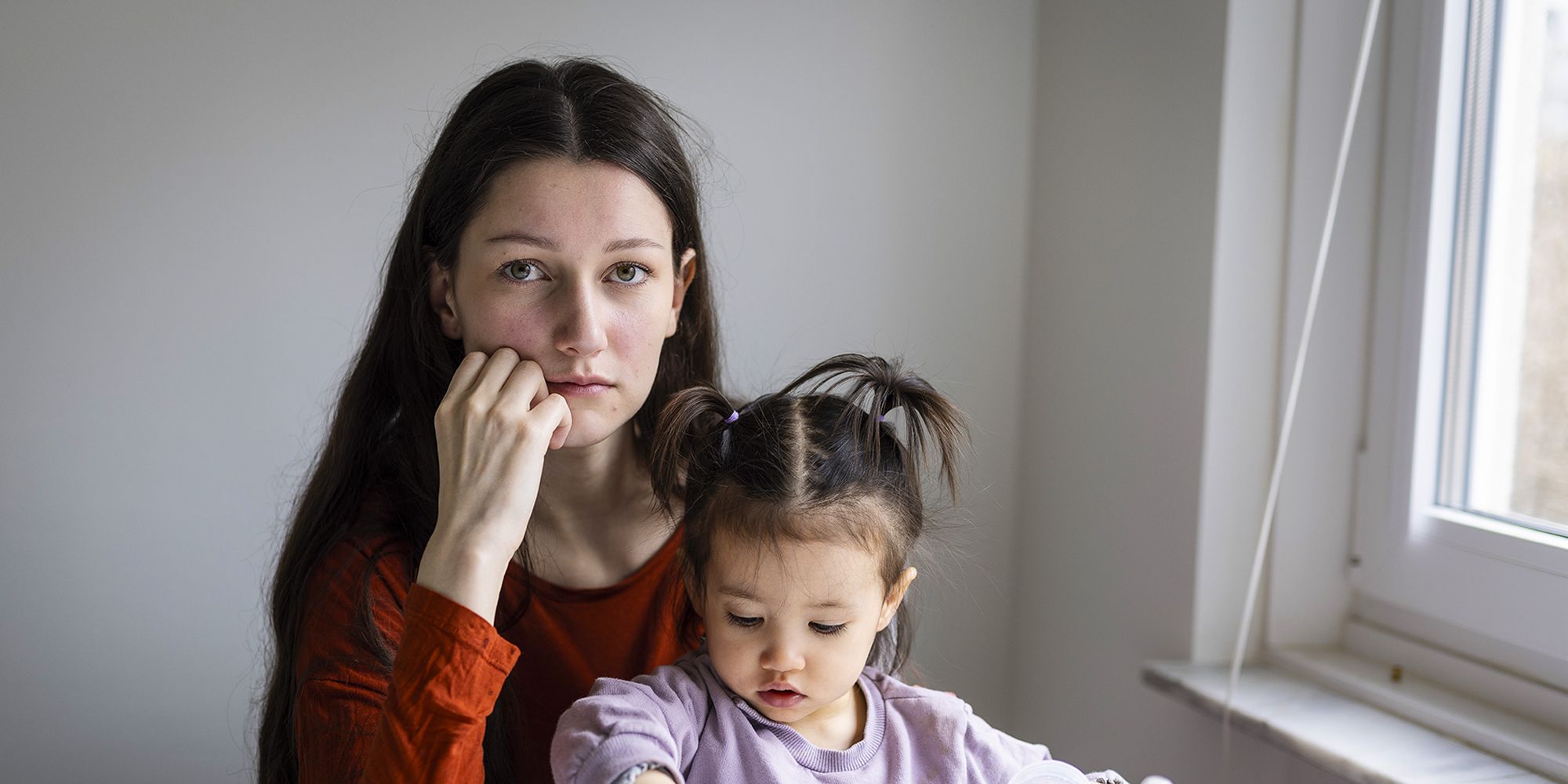 Mamma sitter med dotter och tittar in i kameran.