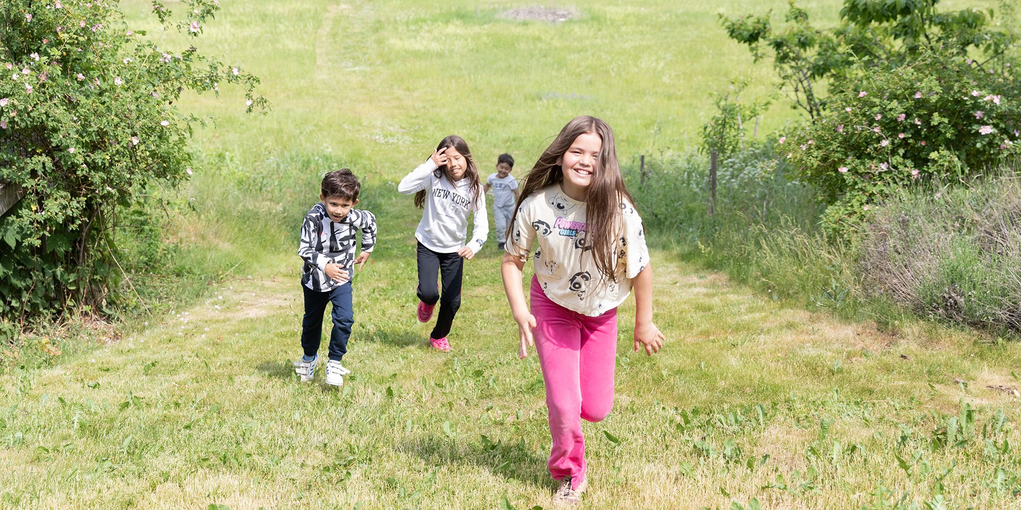 Barn springer på en sommaräng