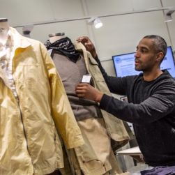 Man fixar till kläder på en skyltdocka i en av second hand-butiker.