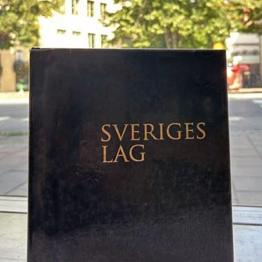 Bild på lagbok, i bakgrunden diffus gatubild