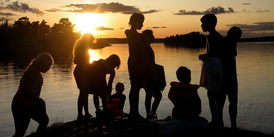 Barn i motljus en sommarkväll