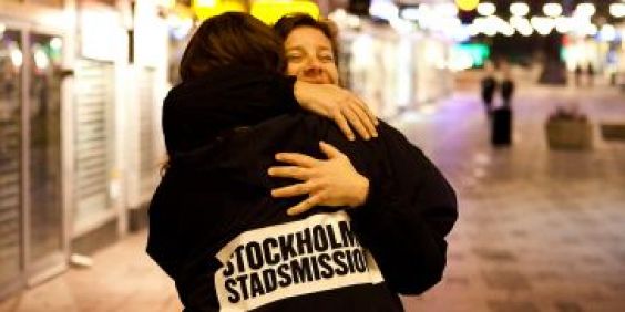 Medarbetare kramar om kvinna på stan