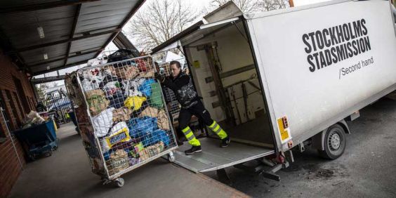 En man lastar av skänkta kläder och prylar från en lastbil