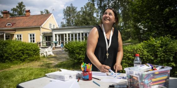 Volontär på sommarkollo förbereder pyssel.