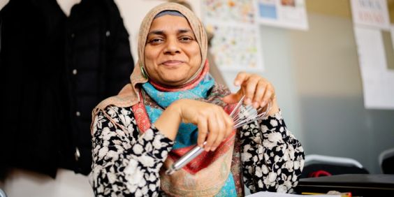 En elev på Stadsmissionens folkhögskola sitter med en visp i handen.