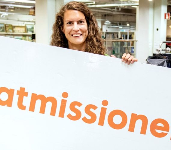 Tjej med skylt med texten Matmissionen.