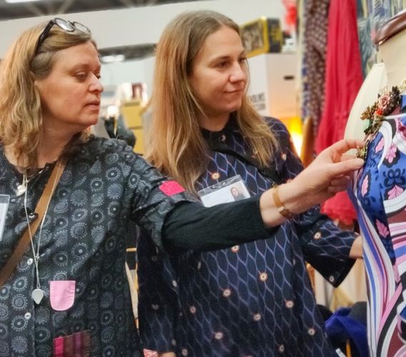 Två kvinnor tittar på antika kläder.