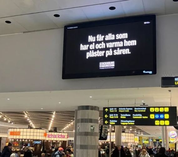 Tv-skärm på Centralstationen som visar Stockholms Stadsmissions kampanjbudskap.