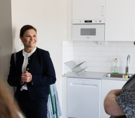 Kronprinsessan Victoria pratar med en hyresgäst när hon besöker Stockholms Stadsmissions delningsboende i Vega.
