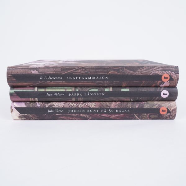 Bokryggar av tre illustrerade klassiker med titlar och författarnamn