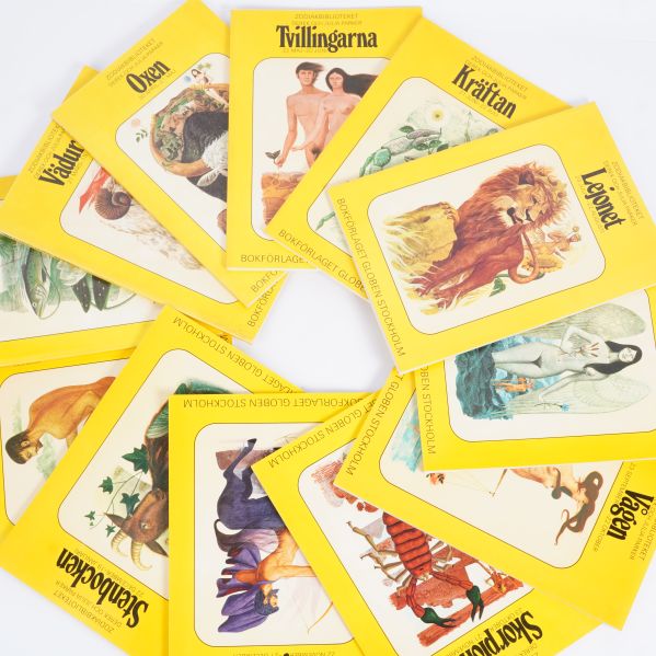 Zodiakböcker utspridda i en cirkel, färgrika omslag syns