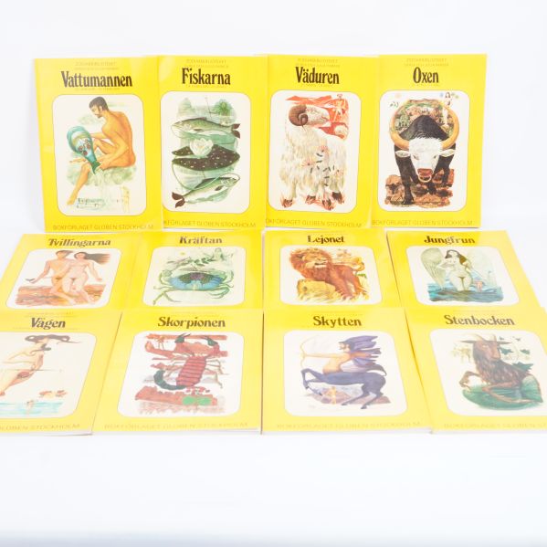 Tolv gula böcker med astrologiska tecken på framsidan