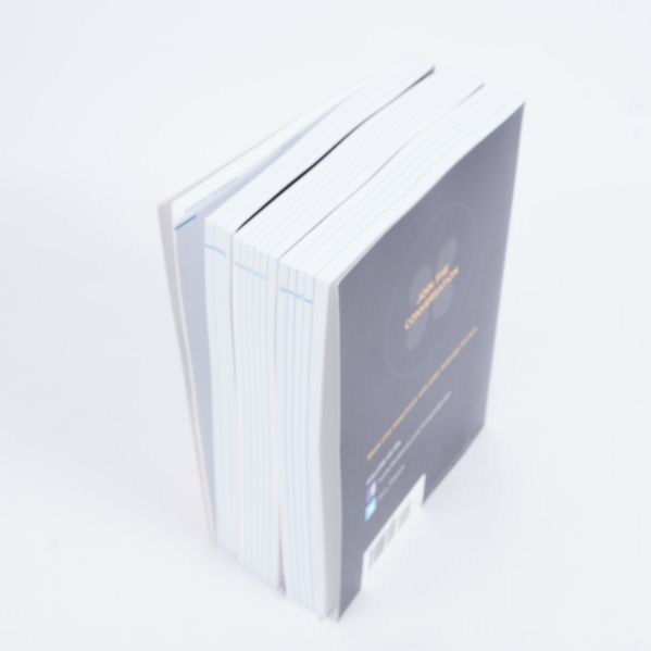 Böckerna ses uppifrån med tydliga vita sidor och svarta omslag