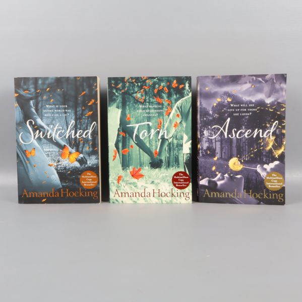 Tre böcker av Amanda Hocking med fantasifulla omslag och titlarna Switched, Torn, Ascend