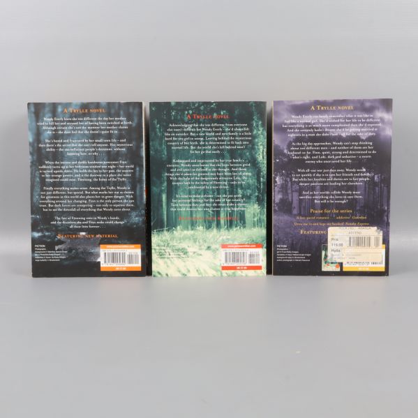 Baksidor på tre böcker ur Trylle-trilogin med skogsbakgrunder och text