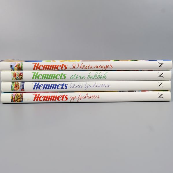 Ryggar på Hemmets kokböcker med boktitlar i olika färger staplade på rad