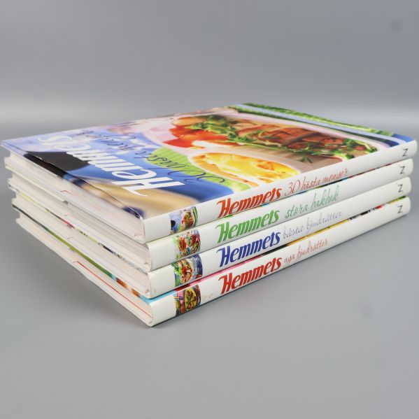 Snett staplade Hemmets kokböcker med tydlig visning av omslag och ryggar