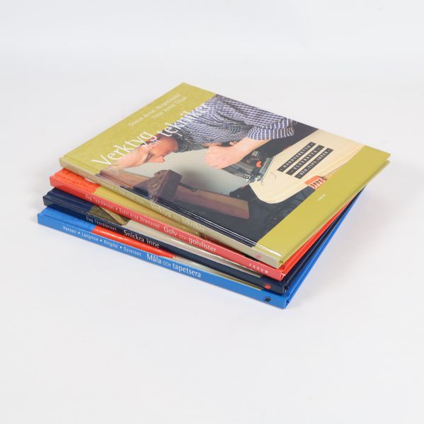 Fyra böcker i lutande hög synliga från sidan