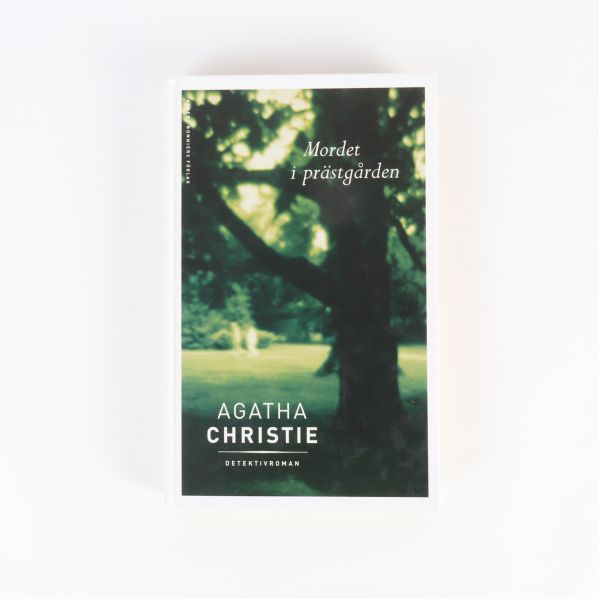 Framsidan av Mordet i prästgården av Agatha Christie med suddig grön bakgrund