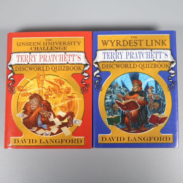 Två böcker Terry Pratchett's Discworld Quizbook liggande bredvid varandra med färgstarka omslag